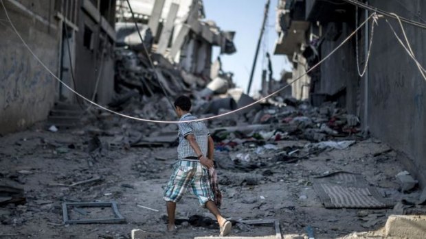 A Palestinian boy walks amid the rubble of destroyed buildings on Sunday in the Shejaiya residential district of Gaza City. 