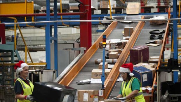Australia Post workers sort through a never-ending line of parcels at Victoria's Sunshine West depot.