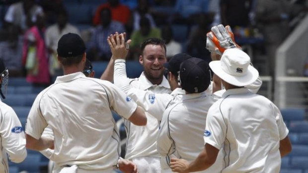 New Zealand's Mark Craig, centre, celebrates with teammates taking the wicket of Kirk Edwards.