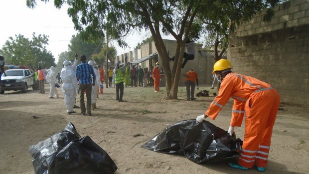 Emergency personnel collect bodies following an attack by suicide bombers at the outskirts of Maiduguri, Nigeria in February. 