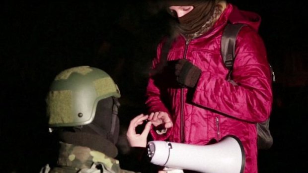 A protester puts a ring on his girlfriend's finger during a wedding proposal in Kiev.