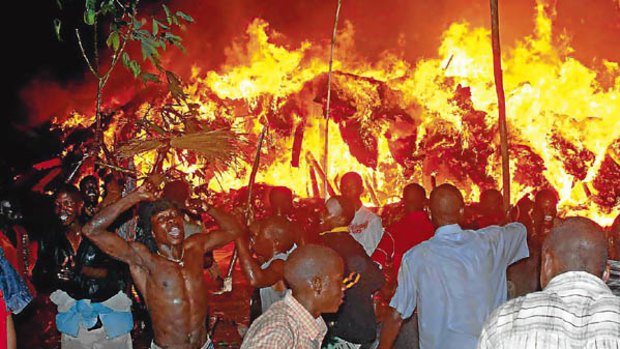 Supporters of Ronald Muwenda Mutebi II watch the Kasubi tombs go up in flames.