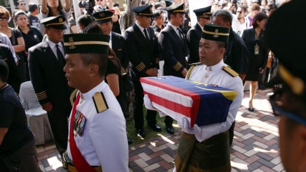 Malaysian Army soldiers carry an urn containing ashes of pilot Eugene Choo of Flight MH17 shot down over eastern Ukraine in July, at his home in Seremban, Malaysia.