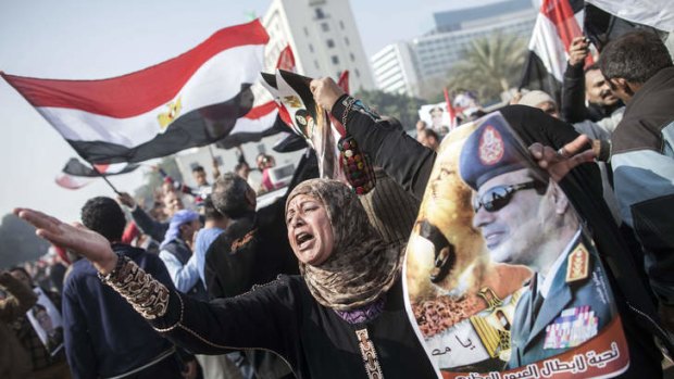 An Egyptian supporter of the military-installed government holds a poster bearing a portrait of General Abdel Fattah al-Sisi as she takes part in a rally marking the anniversary of the 2011 Arab Spring uprising in downtown Cairo.