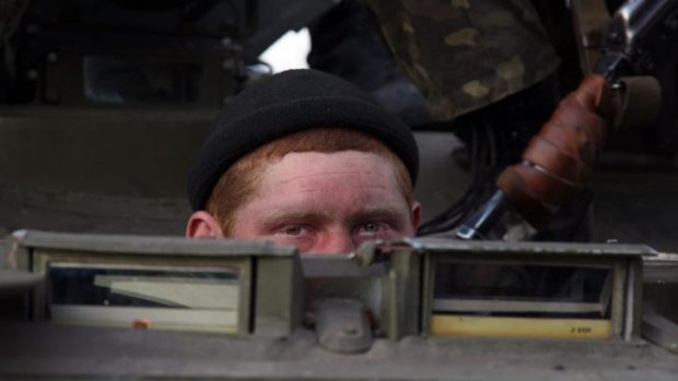A soldier peeks out as a column of Ukrainian armoured vehicles were blocked by pro-Russia supporters in Kramatorsk.