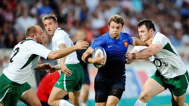 Vincent Clerc of France runs at a gap between Ireland hooker Rory Best and centre Paddy Wallace.