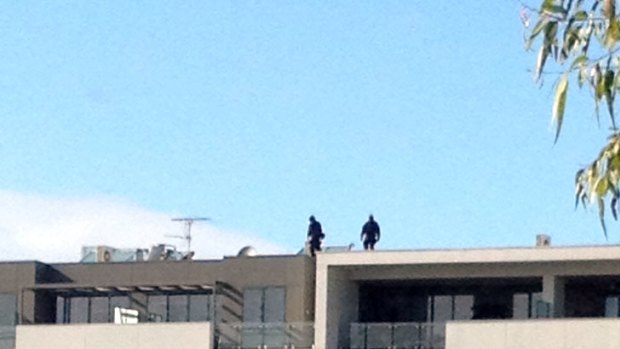 Tactical police on the roof of an apartment building in Maribyrnong.
