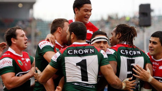 Running riot: Souths celebrate another try in the Charity Shield match against the Dragons.