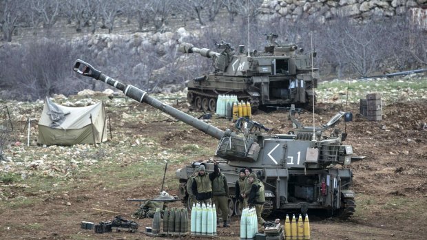 Israeli soldiers stand next to a mobile artillery unit near the border with Syria in the Golan Heights on Wednesday.