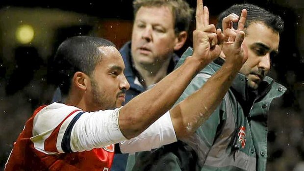 What's the score: Theo Walcott gestures to the Spurs fans the score of 2-0.