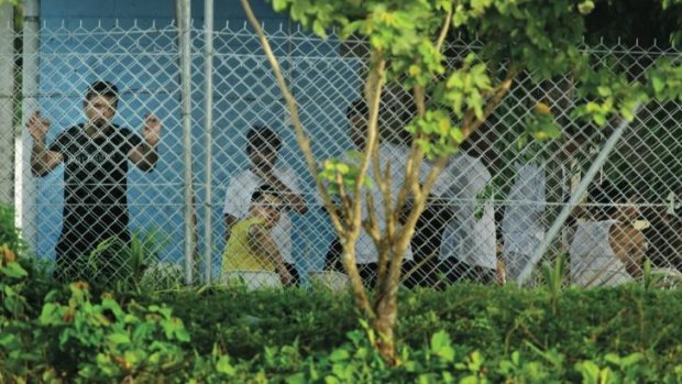 Asylum seekers behind wire on Manus Island last year.