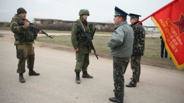 Tense exchange ... Colonel Yuli Mamchor (C-R), commander of the Ukrainian military garrison at the Belbek airbase, and a colleague bearing the regiment flag, confront troops under Russian command occupying the Belbek airbase in Crimea. Warning shots were fired by the pro-Russian forces as they approached.
