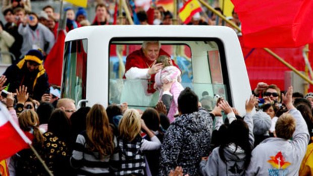 A blessing for some ... Pope Benedict meets a young follower at World Youth Day, which cost $86 million.