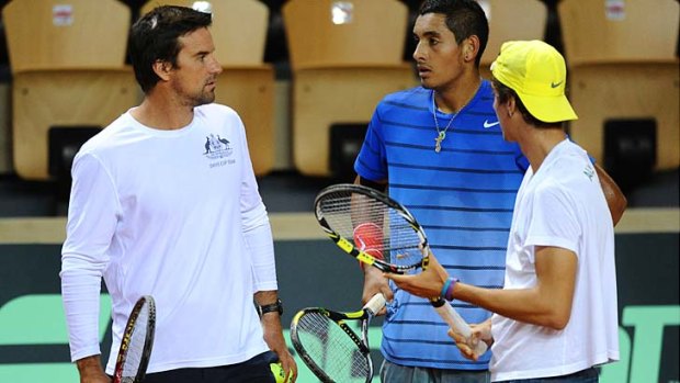 Australia's Thanasi Kokkinakis (right) and Nick Kyrgios (center) talk with their captain Patrick Rafter during in a training session two days before the Davis Cup first round clash with France.