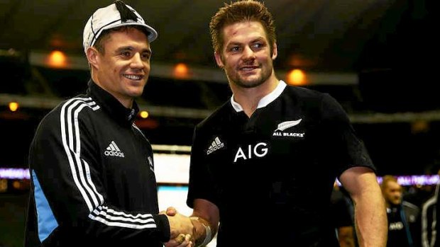 Dan Carter of New Zealand receives his 100th cap from his skipper Richie McCaw.