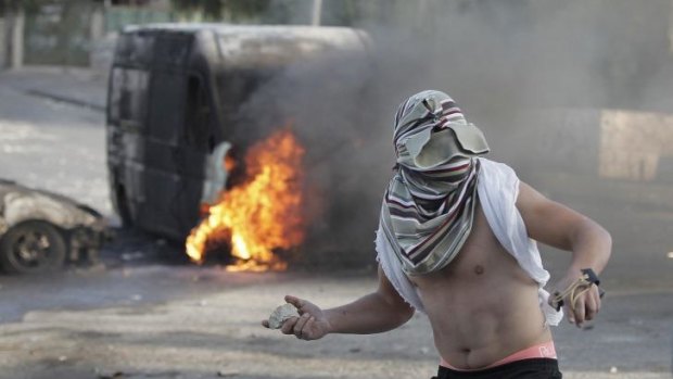 A Palestinian youth throws a rock during clashes with Israeli security forces in occupied East Jerusalem on Thursday.