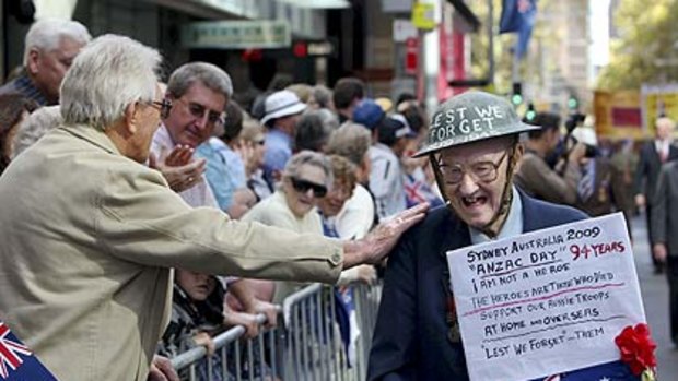 Good on ya . . . Pat Lee , a 94-year-old veteran,  is congratulated by the crowds lining the street.