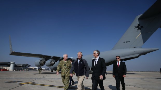 Prime Minister Malcolm Turnbull, centre, exits a C-17 Globemaster after arriving in Baghdad, Iraq, during a visit to meet with troops involved in Operation Okra, on Saturday. 