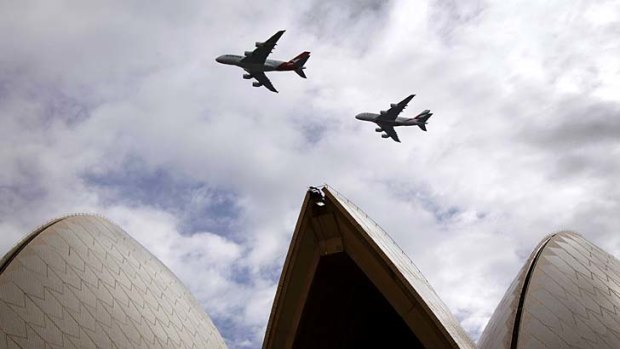 A Qantas (L) and an Emirates Airbus A380 fly in formation above the Sydney Opera House on Sunday to mark the commencement of the five-year alliance between the airlines.