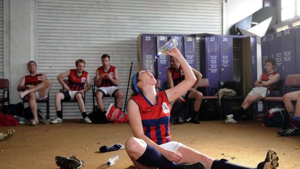 Maree Fewster takes a long, cold drink after her team, the Vain, won its game in the Renegade Football League yesterday.