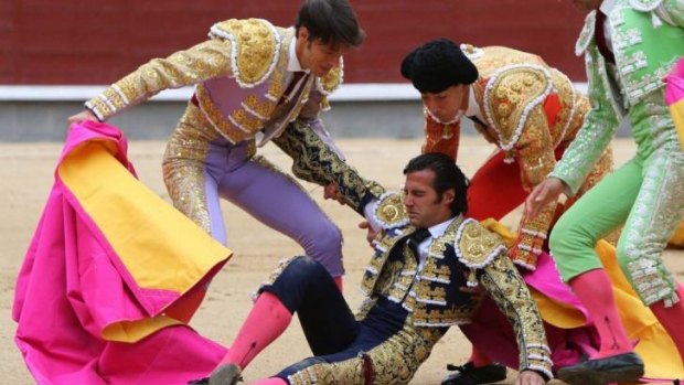 Assistants help Spanish matador David Mora after he was gored by an angry bull named Deslio at Madrid's prestigious Las Ventas bullring.