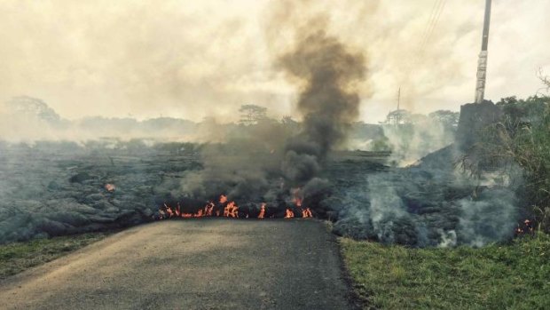 On the move: The lava flow from the Kilauea volcano crosses Cemetery Road near the village of Pahoa.