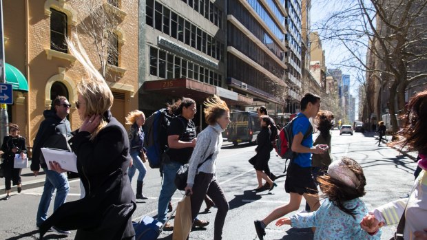 Pedestrians in Sydney struggle in the windy conditions.