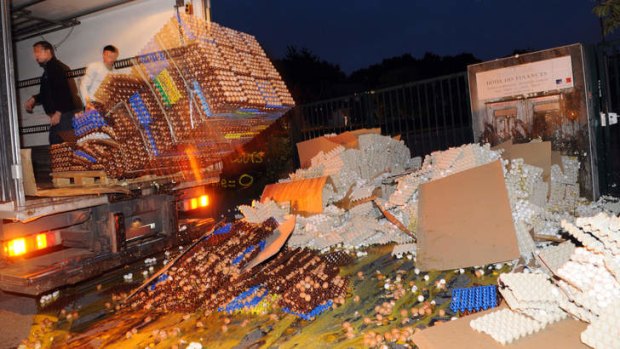 French egg producers throw crates of eggs from the back of a truck outside a tax office in Brittany.