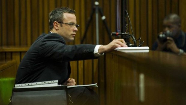 Sickened: Oscar Pistorius, wearing glasses to write notes, in the dock on Thursday.