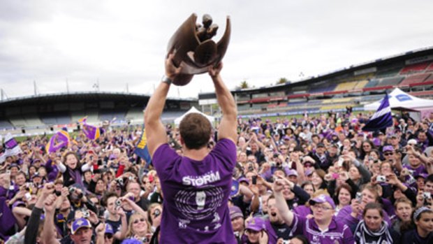 Melbourne Storm second-rower Ryan Hoffman holds aloft the 2009 NRL premiership trophy in front of the team's loyal fans in Melbourne.
