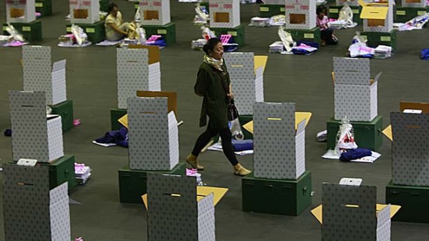 An election official walks amid ballot boxes and accessories bound for polling stations in Bangkok, Thailand.