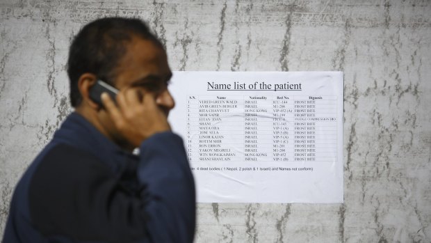A man from a local travel agency reads out names from a list showing patients who were rescued from the recent avalanches and undergoing treatment at an army hospital in Kathmandu.