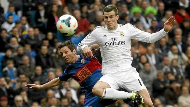 Flying high: Real Madrid's Gareth Bale challenges Elche's Edu Albacar for the ball.