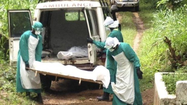 Health workers carry the body of an Ebola virus victim in Kenema, Sierra Leone.