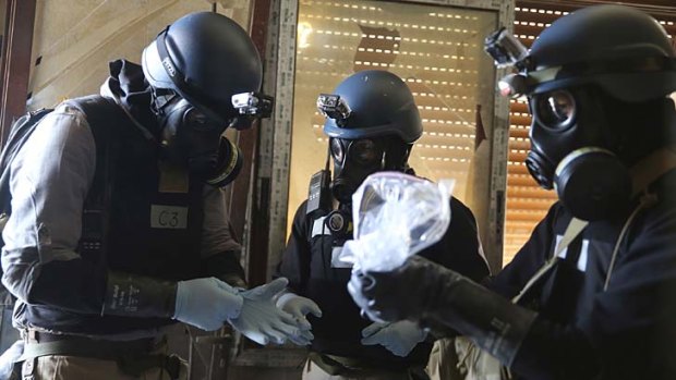 On patrol: A UN chemical weapons expert, wearing a gas mask, holds a plastic bag containing samples from one of the sites of an alleged chemical weapons attack in the Ain Tarma neighbourhood of Damascus.