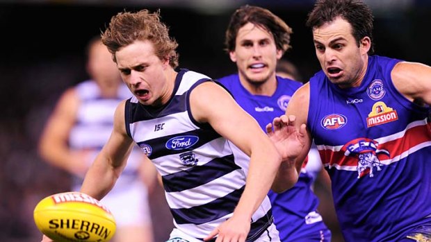 The chase: Geelong's Mitch Duncan and Bulldog Brian Lake battle for possession last night.