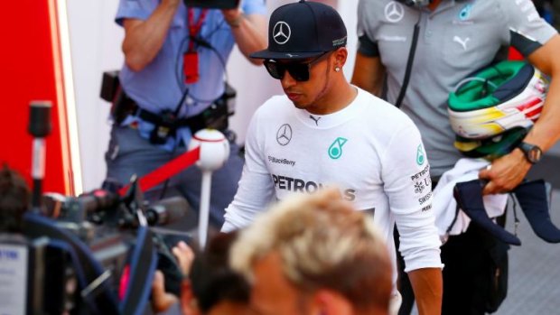 Oops: Lewis Hamilton looks sheepish as he returns to the pits after his crash in qualifying.