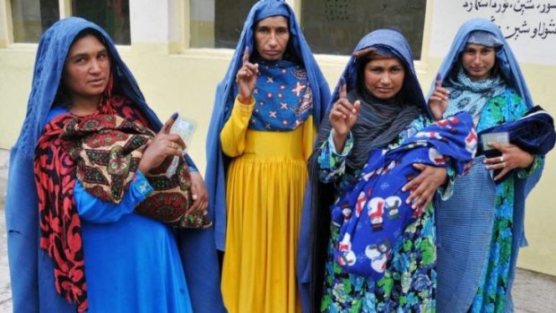 Afghan women show their inked fingers after they cast their vote in Jalalabad.