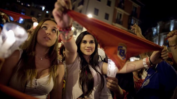 Revellers raise their scarves and candles as they sing the 'Pobre de Mi' song, marking the end of the San Fermin festival.