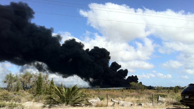 A thick plume of black smoke rises from the tanker blaze.