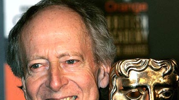 John Barry poses with the BAFTA Fellowship award in 2005.
