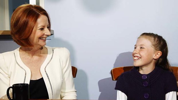 Prime Minister Julia Gillard discusses the carbon tax with Hannah Cochrane at the family's home in west Sydney yesterday.