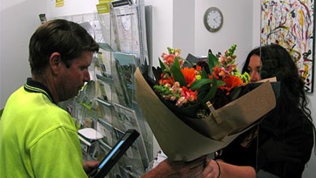 A staff member receives flowers at Councillor Nicole Johnston's Tennyson ward office yesterday.