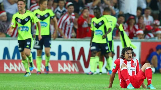 Flattened: Heart's David Williams sits dejected after Archie Thompson's winning goal.