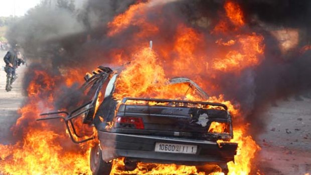 A car burns during a demonstration in Marrakesh.