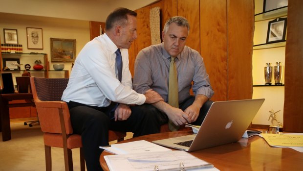 Prime Minister Tony Abbott poses with the Treasurer Joe Hockey as they look through the Budget papers in May 2015. 