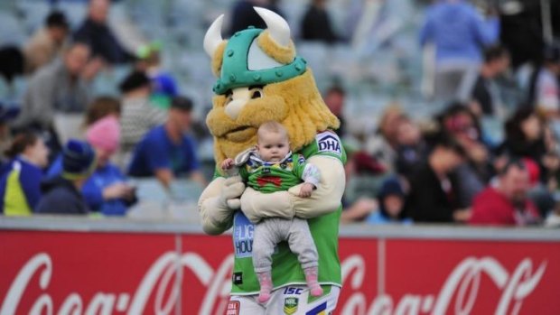 Canberra Raiders mascot Victor the Viking holds Lily Arthur, 8 months, of Banks.