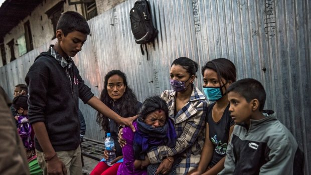 A grieving woman is consoled at a cremation in Kathmandu.