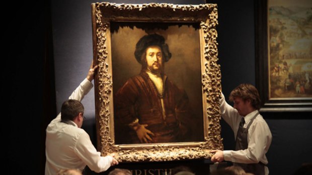 Christies auction house employees carry the Rembrandt masterpiece Portrait of a Man with Arms Akimbo, which sold for a record price of  £20.2 million.