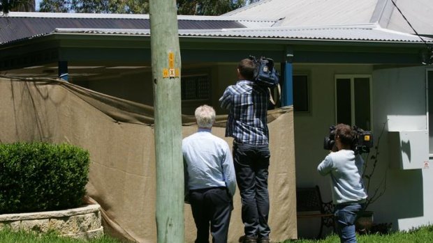 Members of the press try to see inside the boy's house at Morisset Park.